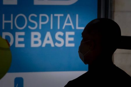 Homem careca de de máscara olha para o lado