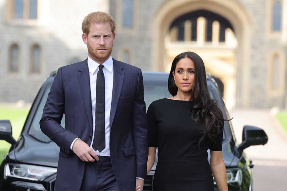 Foto colorida de um casal em frente a um carro