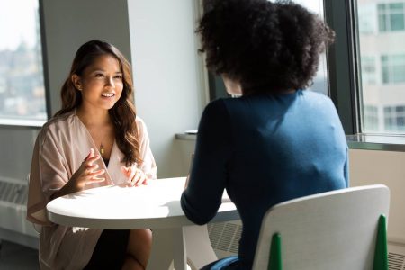 Foto colorida de duas mulheres conversando