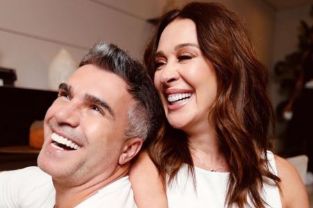 Jarbas Homem de Mello e Claudia Raia. Ele tem pele clara, cabelo curto preto com fios brancos e usa uma camisa branca. Ela usa um vestido branco, está de cabelo castanho claro solto e tem pele clara. Os dois estão sorrindo- Metrópoles