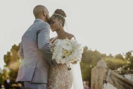 Foto colorida de IZA e Sérgio Santos no casamento, cantora usa vestido de noiva e ele, terno - Metrópoles