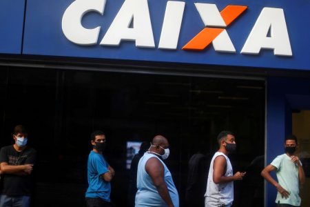 Pessoas em frente a uma agência da Caixa