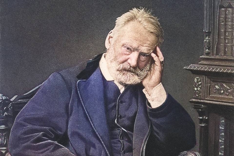 escritor francês victor hugo sentado com a mão na cabeça