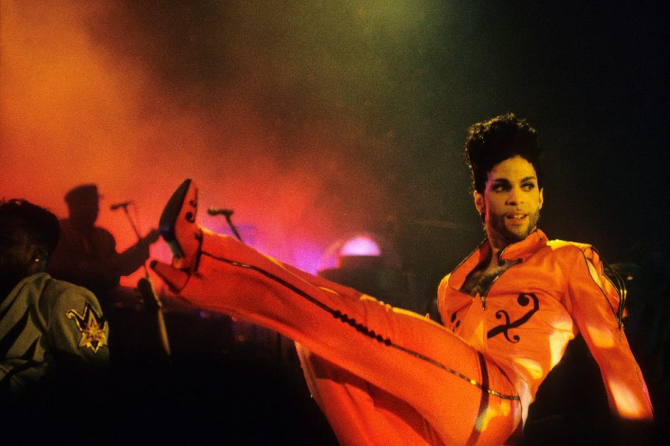 Na imagem com cor, o cantor Prince em apresentação ao vivo