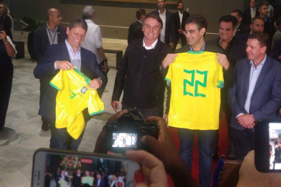Bolsonaro posa ao lado de Tarcísio de Freitas e de Rodrigo Garcia, que seguram camisas da Seleção Brasileira