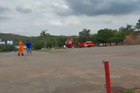 helicoptero pousando e pessoas proximas