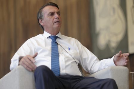 Presidente é Bolsonaro entrevistado pela jornalista Lilian Tahan, do portal Metrópoles. Ambos estão sentado em salão amplo do palácio da Alvorada e o presidente fala gesticulando - Metrópoles