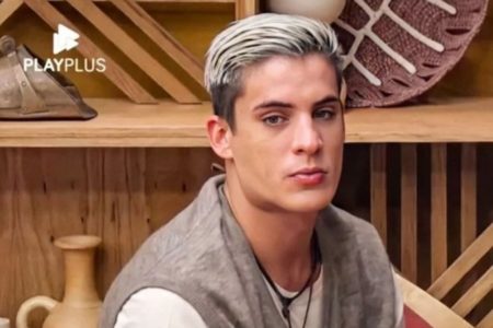 Foto colorida de Tiago Ramos com o cabelo platinado em reality show - Metrópoles