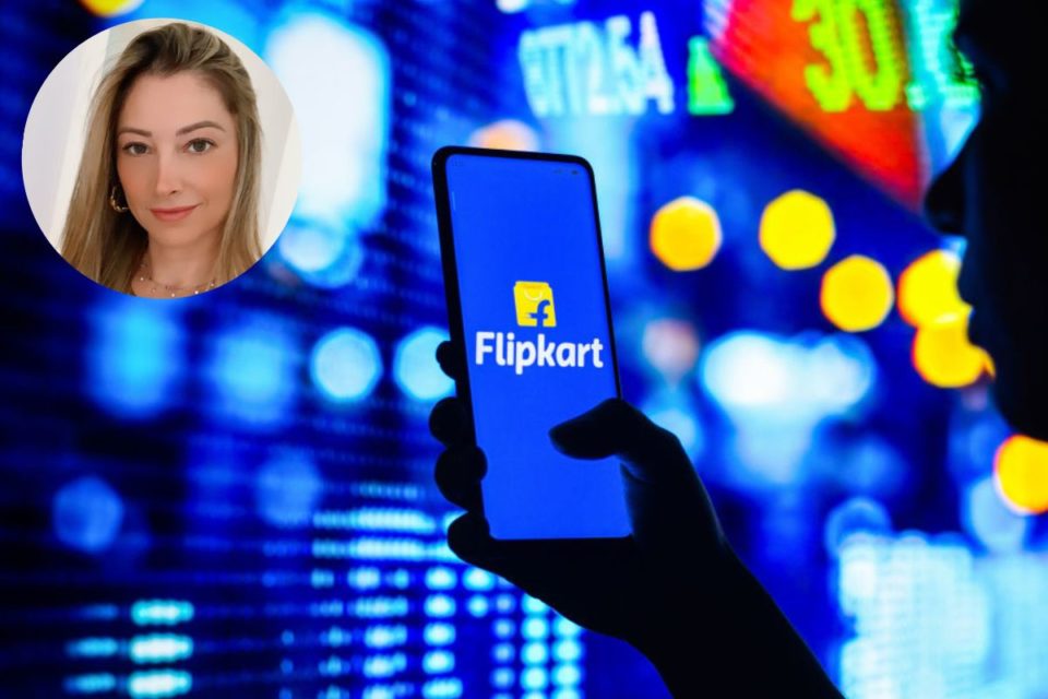 Mãos segurando celular com a logo da Flipkart no metaverso e bolsa de valores ao fundo - Metrópoles