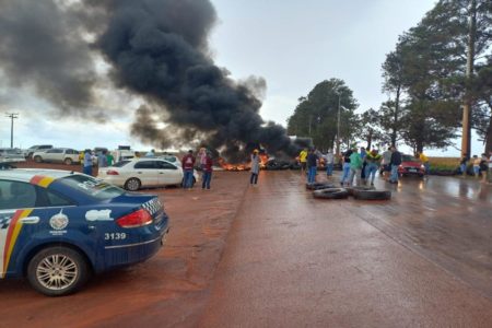 Foto de uma pista com vários veículos e um carro saindo fumaça