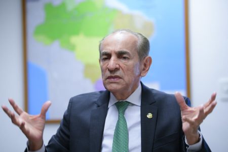 Imagem colorida mostra senador Marcelo Castro (MDB-PI), relator-geral do Orçamento no Senado Federal. Ele gesticula enquanto fala em seu gabinete na casa legislativa. Ao fundo, um mapa do Brasil - Metrópoles