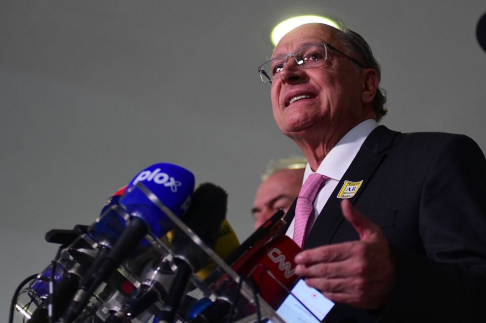 O coordenador da equipe de transição de Lula e vice-presidente eleito, Geraldo Alckmin, dá entrevista diante de púlpito no Senado cercado de outros políticos - Metrópoles