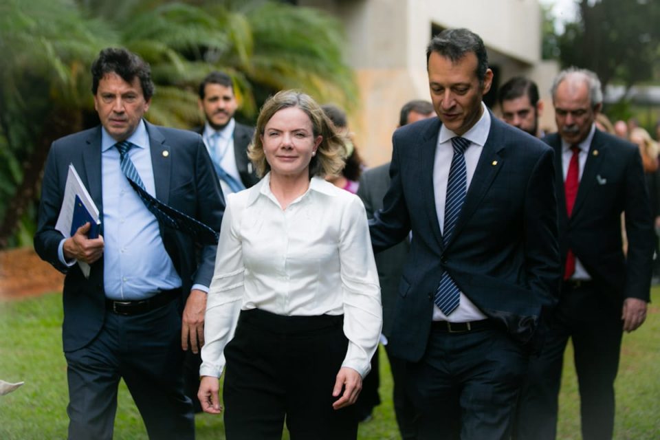 A presidente do PT e membro do governo de transição do presidente eleito Lula, Gleisi Hoffmann, fala em coletiva de imprensa ao ladoe de Aloizio Mercadante e outros políticos. Sorrindo, ela caminha em frente ao Centro Cultural Banco do Brasil, onde ocorre o evento - Metrópoles