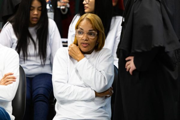 A ex-deputada e cantora gospel Flordelis, acusada de matar o marido, durante julgamento frente à mesa julgadora. Ela usa cabelo curto e loiro, moletom e aparece sentada com os braços cruzados - Metrópoles