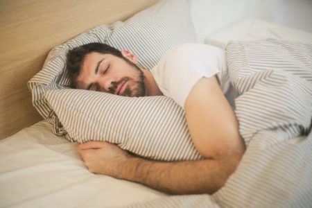 Homem deitado na cama dormindo