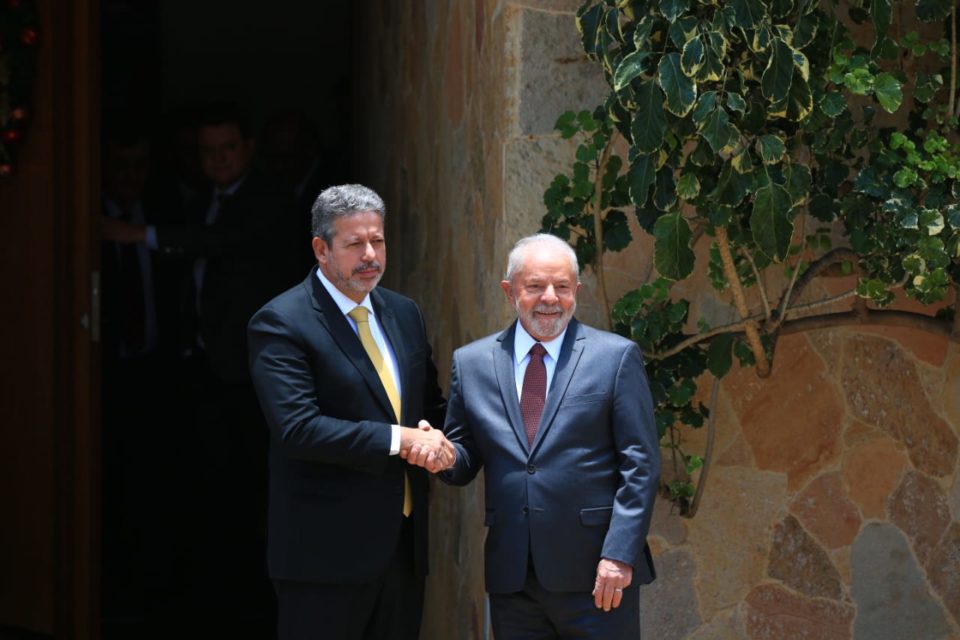 O presidente da Câmara dos Deputados, Arthur Lira, aperta a mão do presidente eleito Lula. Ambos olham para a câmera e sorriem, na porta da residência oficial do presidente da casa legislativa- Metrópoles