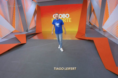 Tiago Leifert, de camiseta azul e calça jeans, volta ao estúdio do Globo Esporte após 7 anos - Metrópoles