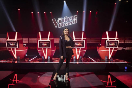 Fátima Bernardes, de figurino preto, posa no cenário do The Voice Brasil - Metrópoles