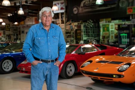 Jay Leno posa para foto ao lado de um de seus carros - Metrópoles