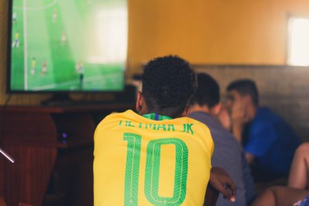 Imagem colorida mostra torcedor assistindo jogo em TV - Metrópoles