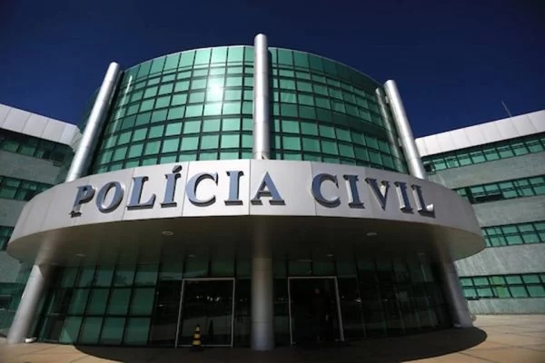 Prédio com janelas verdes espelhadas escrito "Polícia Civil"