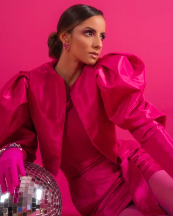 Modelo usa casaqueto rosa brilhoso com luvas e vestido rosa - Metrópoles