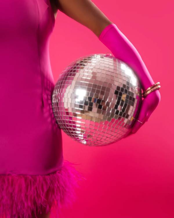 Modelo usa vestido rosa de plumas e segura globo de luz - Metrópoles