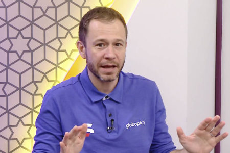 Tiago Leifert, com o uniforme esportivo do Grupo Globo, gesticula durante transmissão da Copa do Mundo no Globoplay - Metrópoles