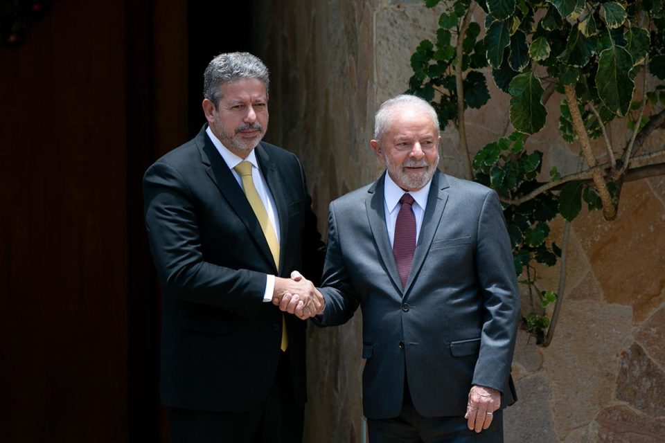 Lula se encontra com Arthur Lira, presidente da Câmara dos Deputados, em sua residência oficial. Na foto, ambos apertam as mãos e sorriem para as fotos - Metrópoles