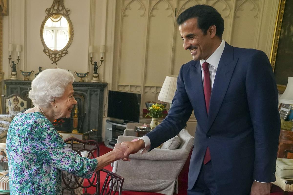 Foto colorida de mulher idosa e branca ao lado de homem pardo e de terno. Eles dão as mãos e estão em uma sala com decoração de luxo - Metrópoles