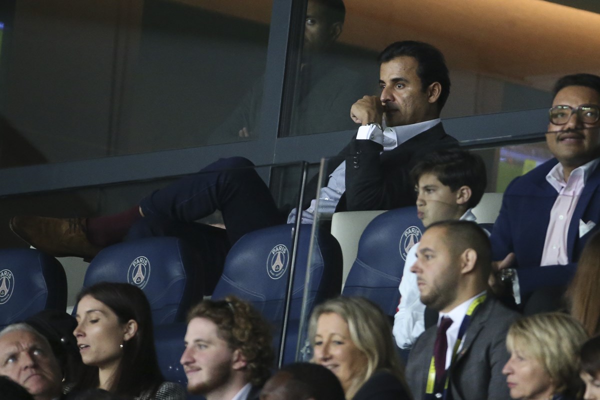 Foto colorida de homens e mulheres sentadas em uma arquibancada com o símbolo PSG - Metrópoles