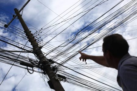 Homem aponta para fio de alta tensão rompido