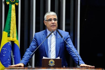 Imagem colorida mostra o senador Eduardo Girão, de terno azul, em um púlpito em frente a uma bandeira do Brasil. Ele anuncia que vai concorrer à presidência do Senado - Metrópoles