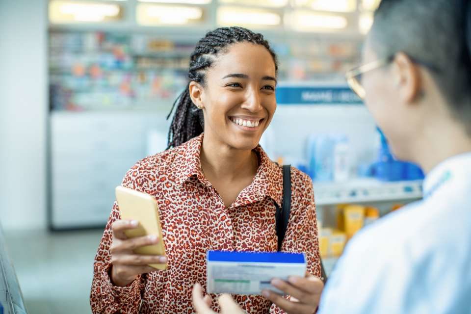 Na foto há duas pessoas conversando, uma mais a frente e outra atrás sorrindo - Metrópoles