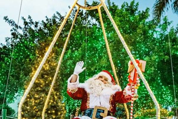 Fotografia colorida mostra o Papai Noel sentado em estrutura iluminada que lembra a cabine de um balão-Metrópoles