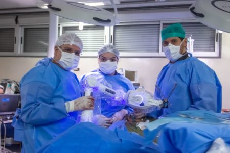 Imagem colorida de equipe médica responsável por cirurgia robótica