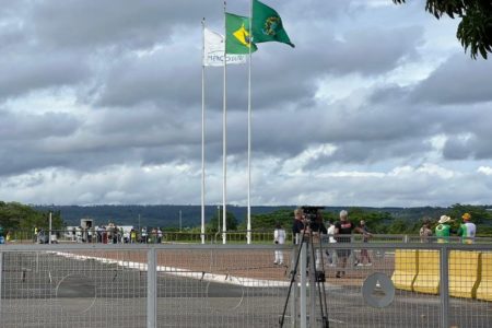 Frente do Palácio da Alvorada no momento da chegada do caminhão de mudança, com manifestantes e jornalistas acompanhando a movimentação - Metrópoles