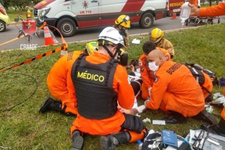 Militares do corpo de bombeiros socorrem homem deitado em maca. Foto colorida