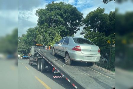 Carro prata em cima de guincho