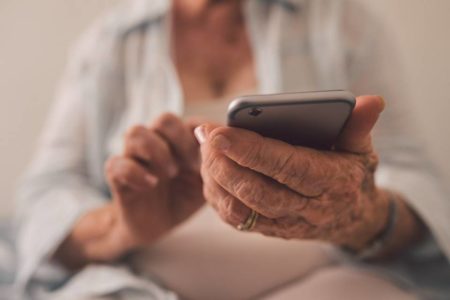 Mãos idosas mexendo em aparelho de smartphone - Metrópoles