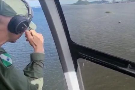 Imagem colorida: bombeiro em helicóptero faz buscas - Metrópoles