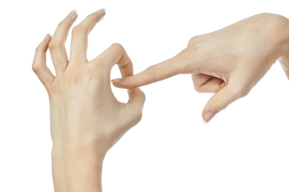 Mãos fazendo gesto de penetração em fundo branco - Metrópoles