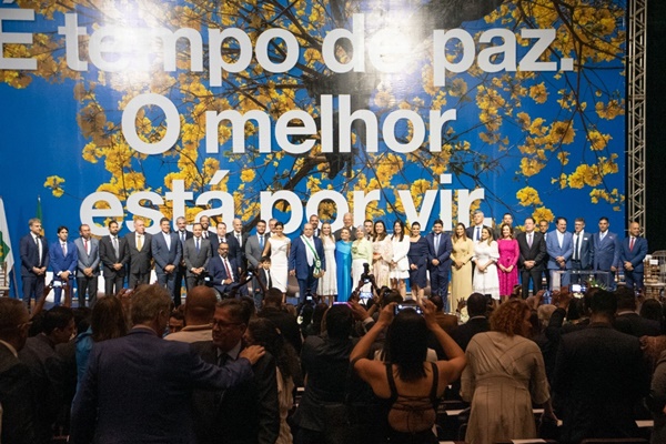 Imagem colorida de grupo de pessoas em palco