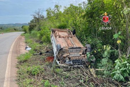 Carro capotado à margem de uma rodovia, no meio do mato, aparece destruído. O acidente deixou idoso ferido no Distrito Federal - Metrópoles