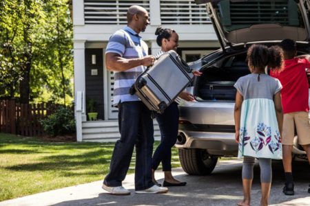 Família colocando malas dentro do carro para viajar