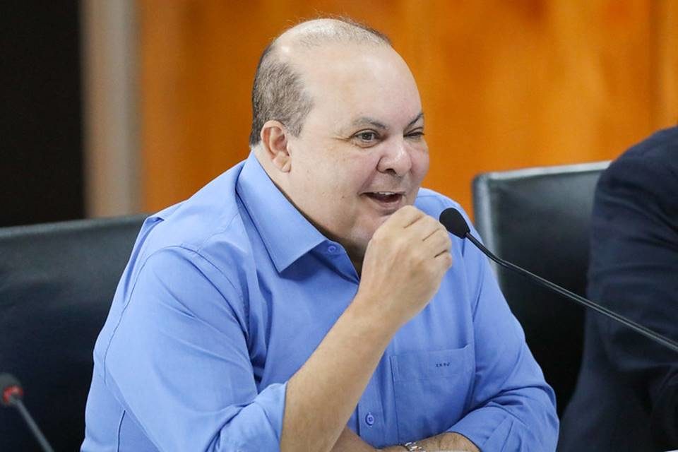 O governador do Distrito Federal, Ibaneis Rocha, fala em reunião no Buriti, sentado diante de microfone. Ele ri - Metrópoles