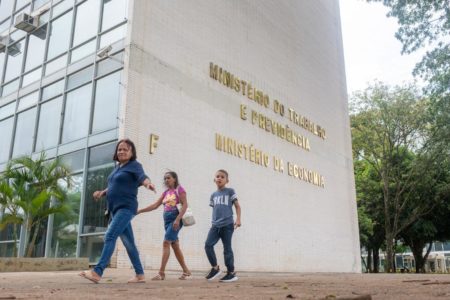 Mulher e crianças passam pelo ministério do trabalho previdencia e economia - Metrópoles