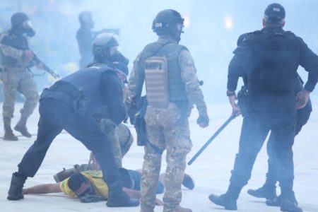 Tropa de Choque da PMDF durante retirada de manifestantes bolsonaristas do Congresso Nacional após invasão no prédio. Agentes detém golpista no chão em meio ao gás - Metrópoles