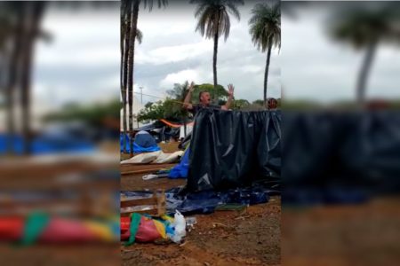 Imagem colorida. Homem em pé com os braços abertos e gritando