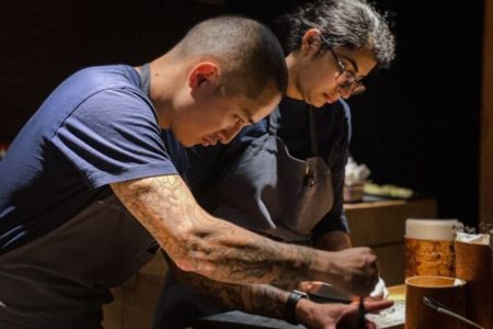 Foto de dois chefs cozinhando no restaurante Noma - Metrópoles